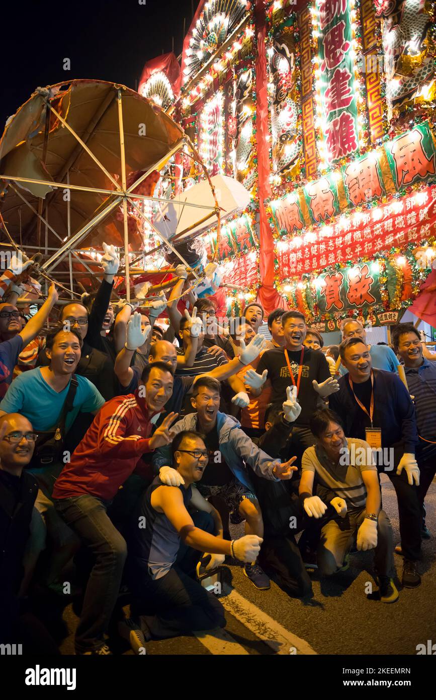 Die Dorfbewohner posieren für Fotos mit dem Bildnis des Geisterkönigs in der Straße in kam Tin in der Nacht während des zehnjährigen Da Jiu Festivals, Hong Kong, 2015 Stockfoto