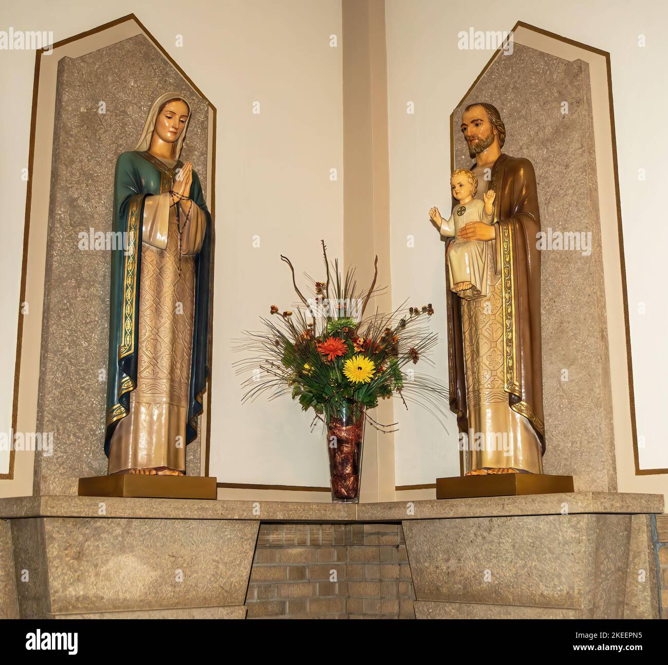 Statuen von Mary und St. Joseph mit dem Jesuskind und einem Blumenstrauß in St. Marias katholische Kirche in Winona, Minnesota, USA. Stockfoto