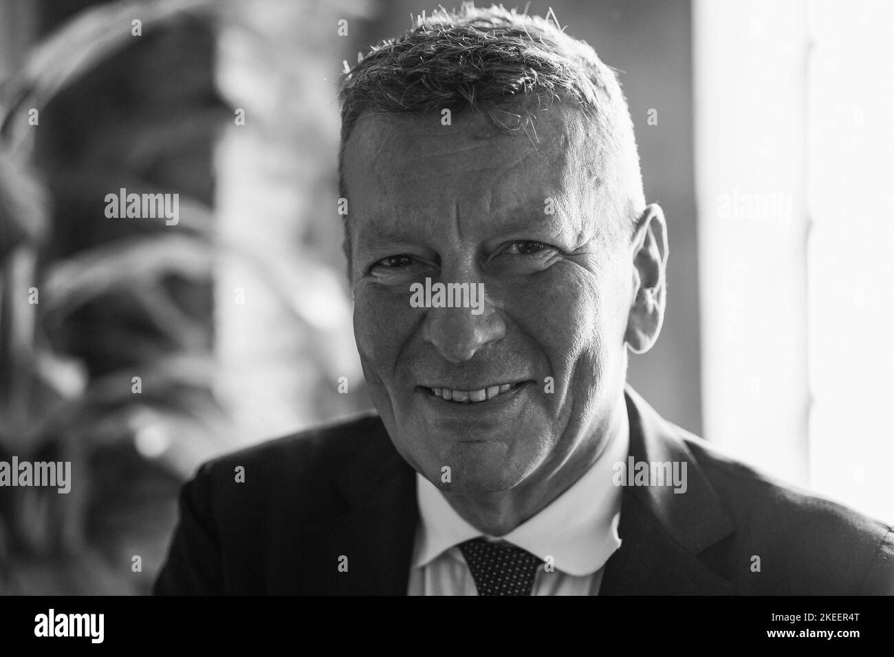 Glücklicher leitender Geschäftsmann, der im modernen Büro arbeitet - Fokus auf Gesicht - Schwarzweißschnitt Stockfoto