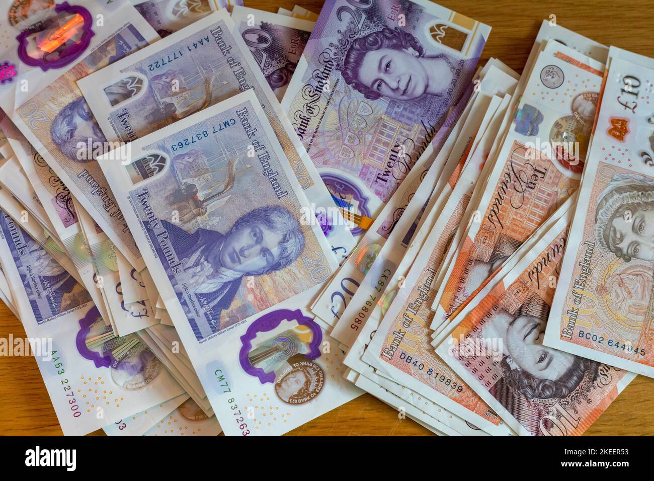 Ein Stapel britischer £20- und £10-Pfund-Scheine auf einem Tisch Stockfoto