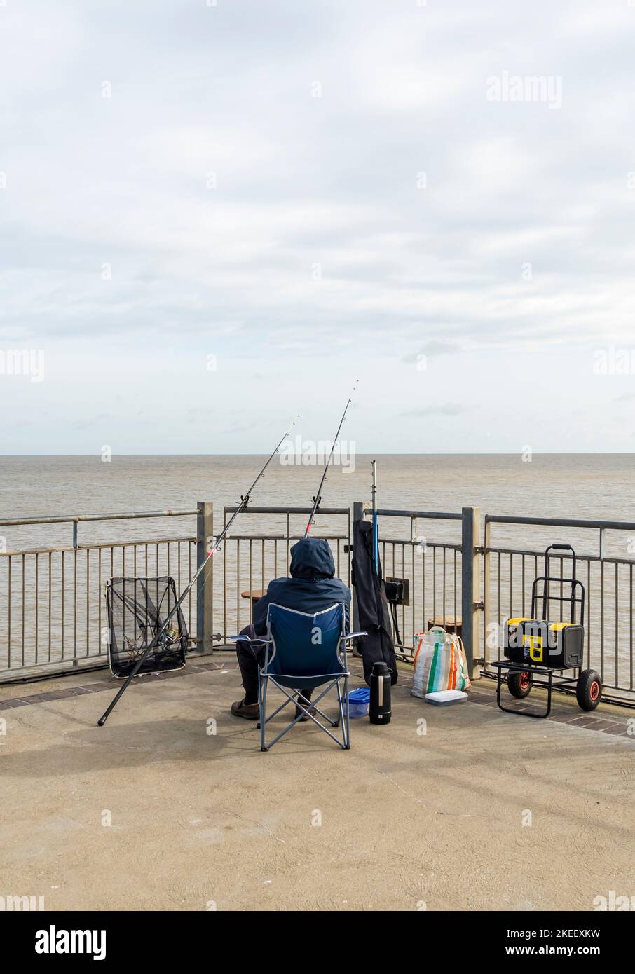 Sitzender Fischer am Ende des Southwold Pier Suffolk 2022 Stockfoto