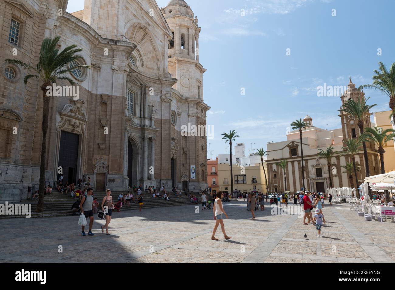 Touristen, die auf der Plaza de la Catedral vor der Catedral de Cááidz spazieren. Cárez, Provinz Andalusien, Spanien. Stockfoto