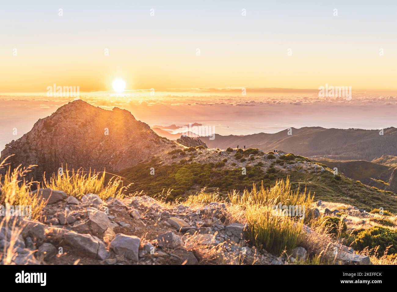 Beschreibung: Touristen beobachten den Sonnenaufgang über der wunderschönen Berglandschaft des Pico do Ariero. Pico do Arieiro, Madeira, Portugal, Europa. Stockfoto