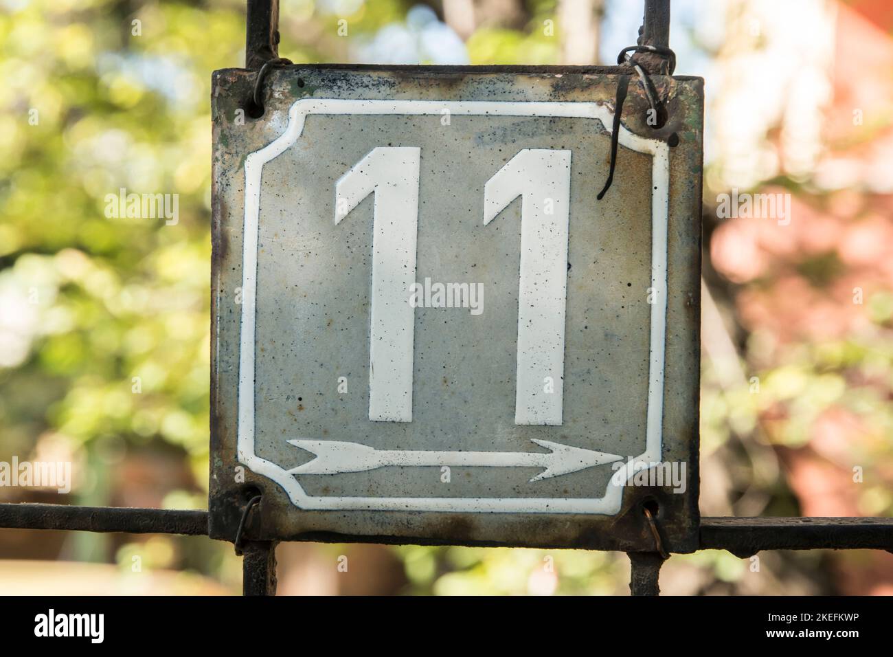 Verwitterte Grunge quadratisch metallisch emaillierte Platte der Nummer der Straße mit der Nummer 11 Stockfoto