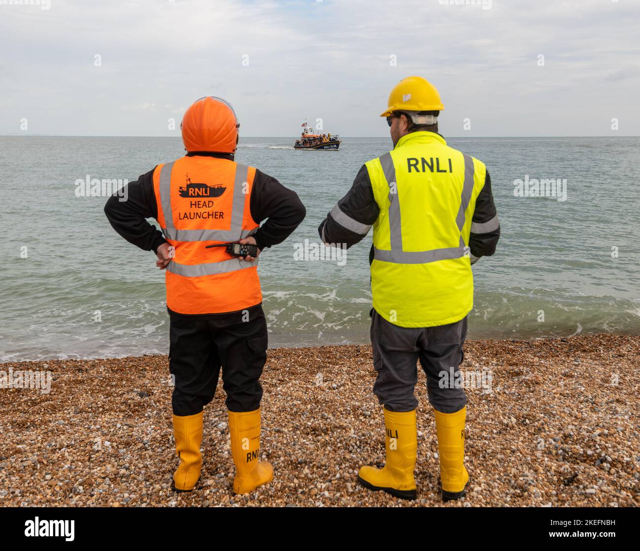 Migranten, die am Strand von Dungeness ankommen und von der RNLI ans Ufer gebracht werden Stockfoto