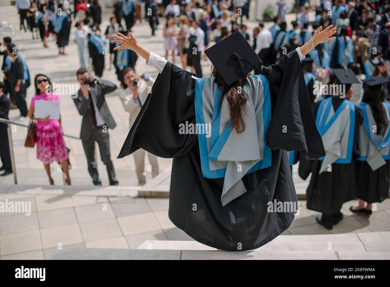 Ein Student an der Universität in Cap and Kittel feiert das Bestehen ihres Doktorgrades Stockfoto