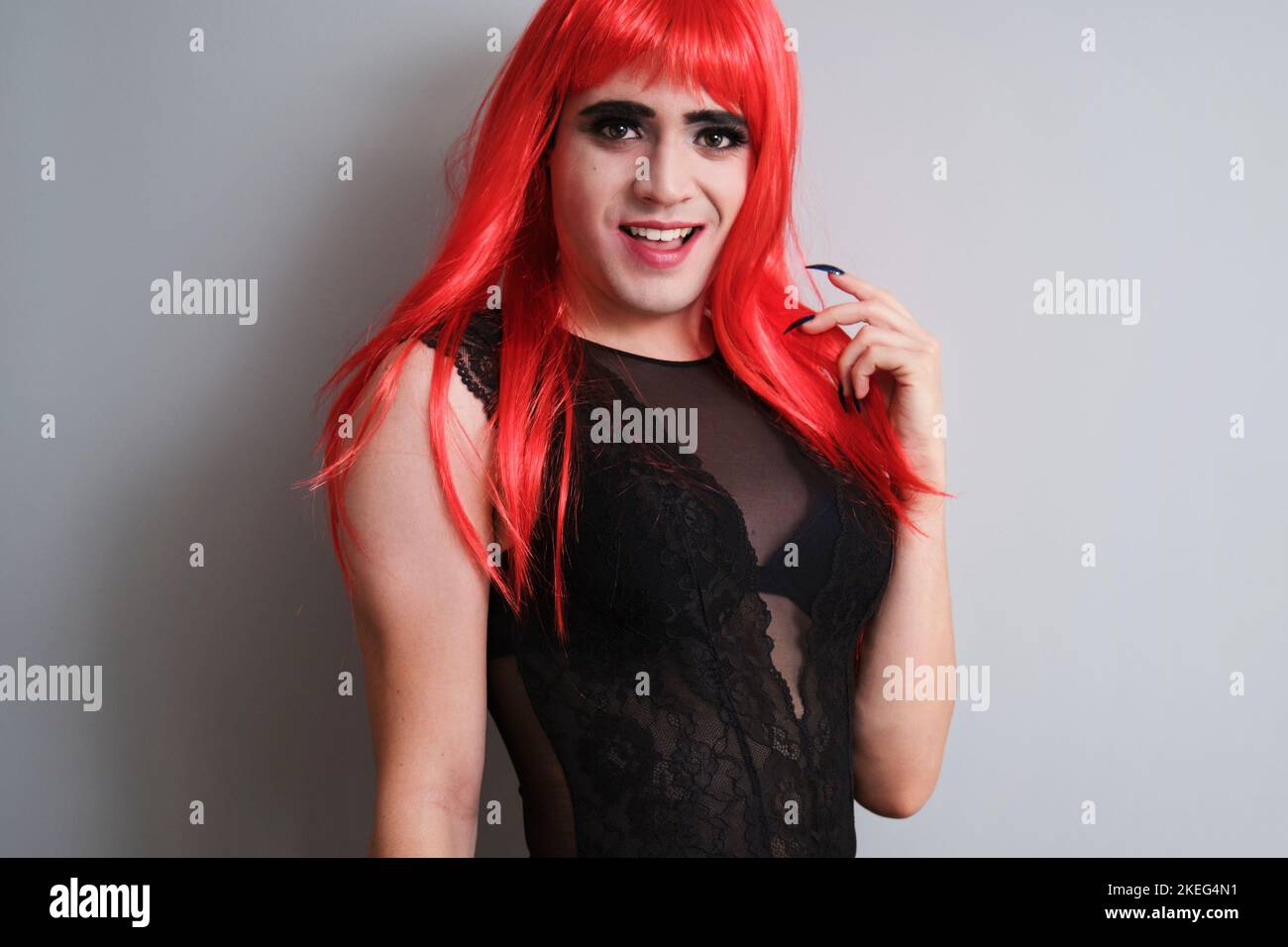 Porträt eines fließenden männlichen Geschlechts, gekleidet als Frau, lächelnd und mit Blick auf die Kamera. Stockfoto