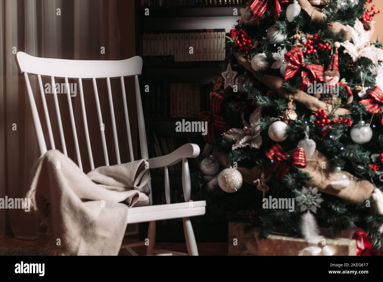 Retro-weißer Schaukelstuhl aus Holz neben einem Weihnachtsbaum Stockfoto