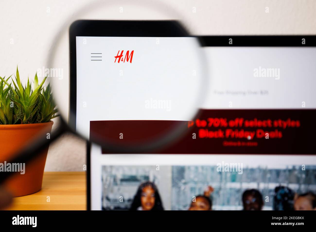 Ein Logo von H&M auf einem Laptop-Bildschirm unter einer Lupe Stockfoto