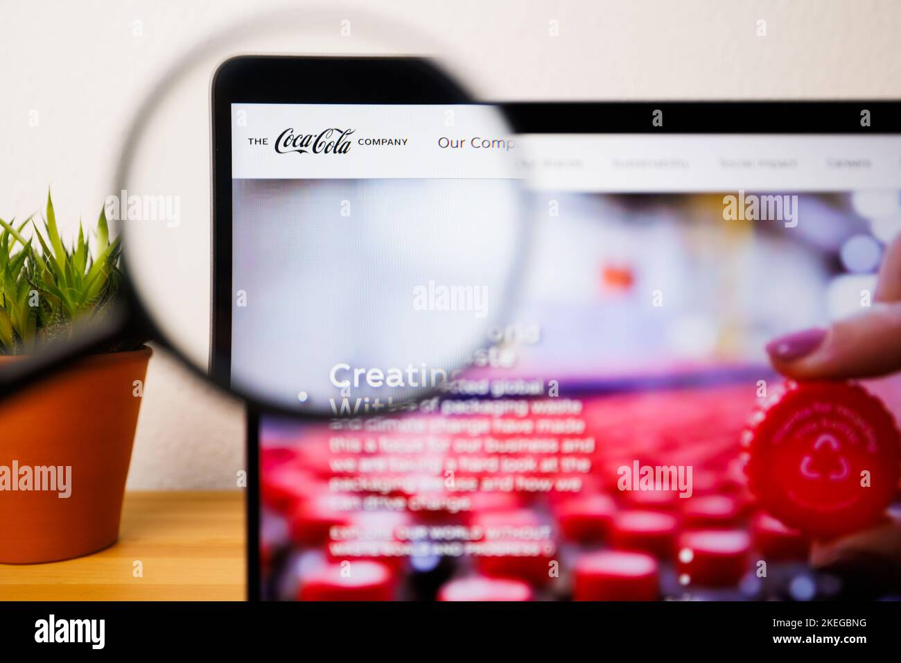 Ein Logo von Coca-Cola auf einem Laptop-Bildschirm unter einer Lupe Stockfoto