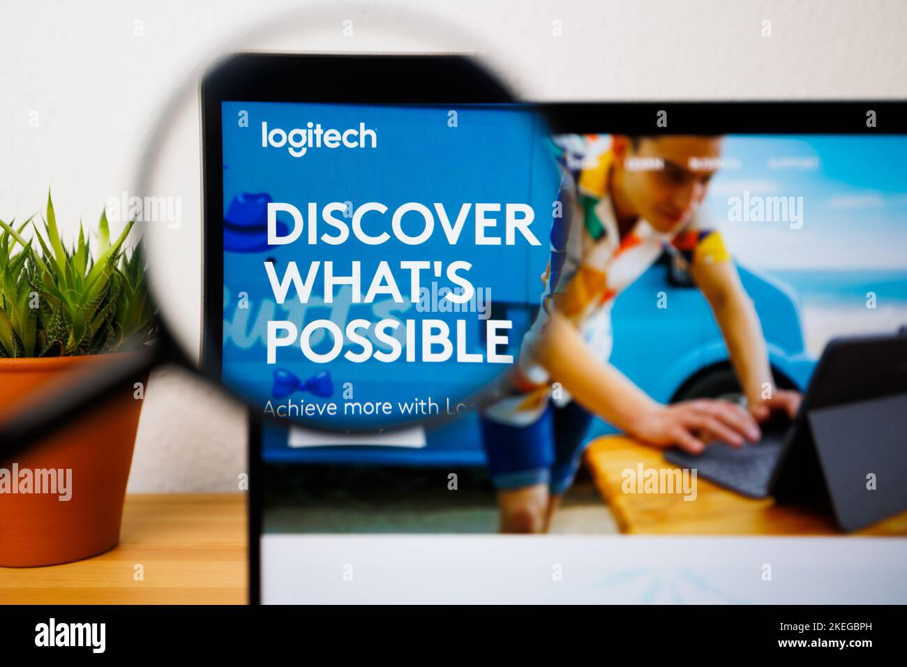 Ein Logo von Logitech auf einem Laptop-Bildschirm unter einer Lupe Stockfoto