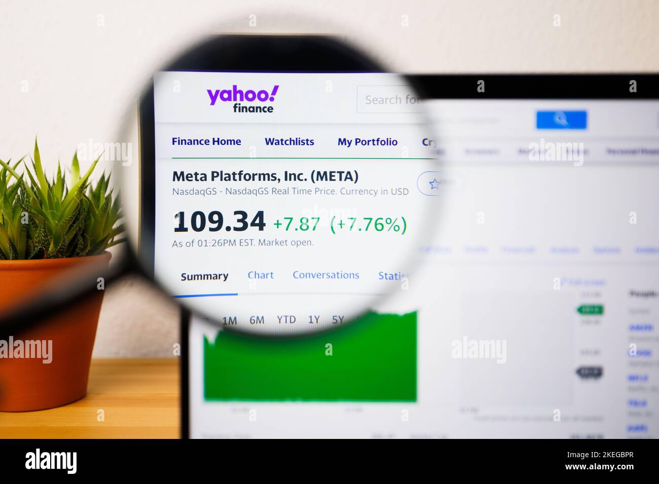 Ein Meta-Aktienkurs auf einem Laptop-Bildschirm unter einer Lupe Stockfoto