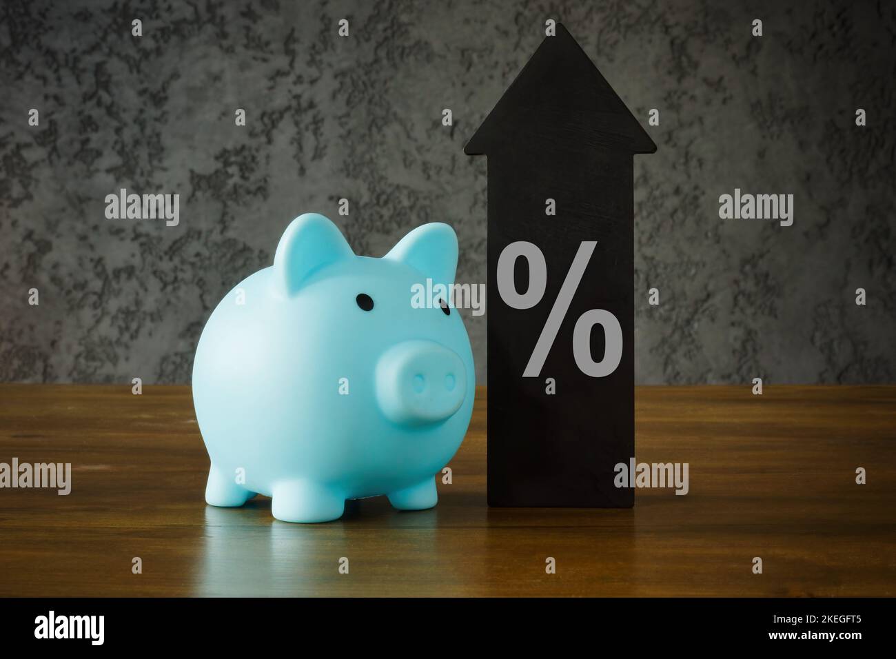 Konzept für das Wachstum von Einsparungen. Sparschwein, Pfeil und Prozentzeichen. Stockfoto