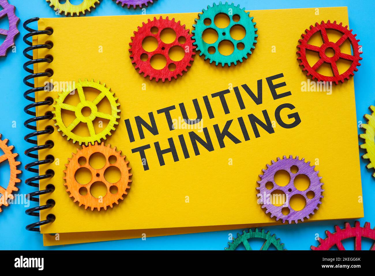 Notizblock mit Ausdruck intuitives Denken und Zahnrädern. Stockfoto
