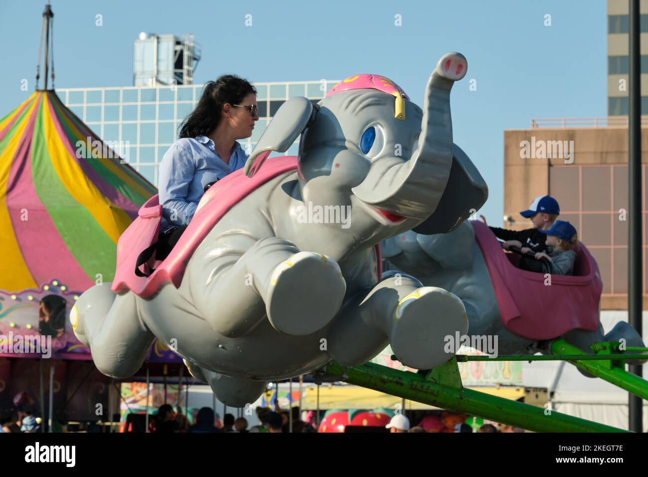 Leute, die auf einem Elefantenkarneval reiten, auf dem Dartmouth Vergnügungsmarkt Stockfoto