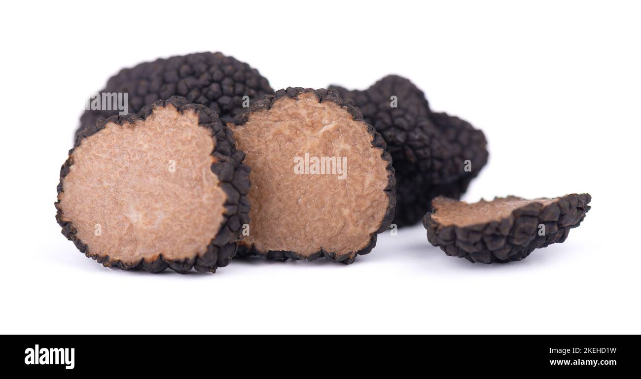 Schwarze Trüffeln isoliert auf einem weißen Hintergrund. Frische Trüffel in Scheiben geschnitten. Delikatesse exklusive Trüffel Pilz. Pikant und duftende Französische Delikatesse Stockfoto