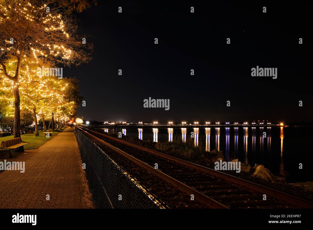 Winterabend am Ufer des White Rock. Farbenfrohe Lichter am Pier bilden Starbursts und hübsche Lichter an den Bäumen sorgen für Glanz. Stockfoto