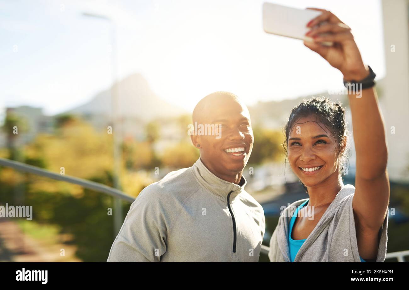 Ein junges, sportliches Paar, das zusammen mit einem Handy ein Foto gemacht hat. Stockfoto