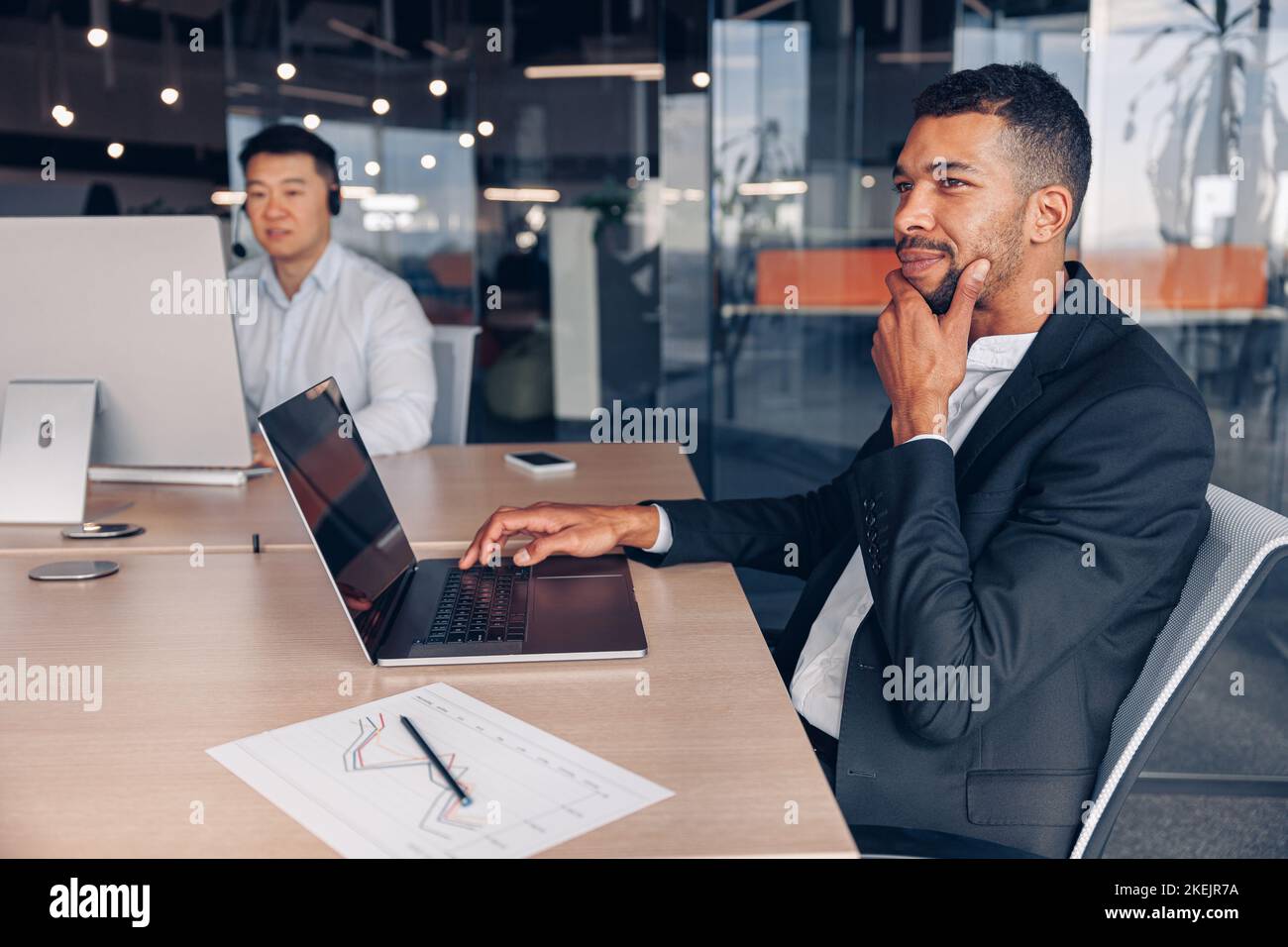 Zwei multirassische Geschäftsleute, die im modernen Coworking arbeiten Stockfoto