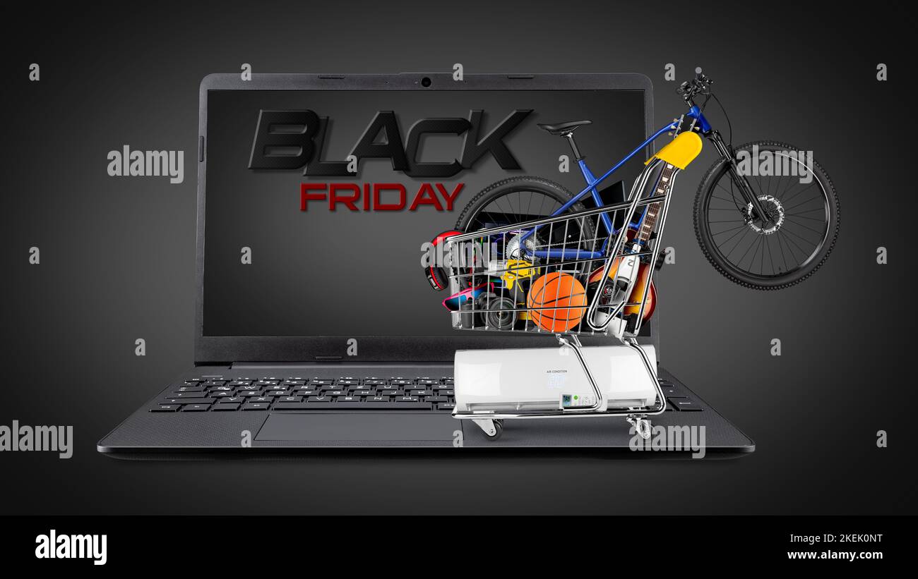 Black friday Online-Shopping-Konzept. Vollständiger Warenkorb gefüllt mit vielen Waren wie Fahrrad Musikinstrumente Elektronik und pc-Hardware auf Notebook auf Stockfoto