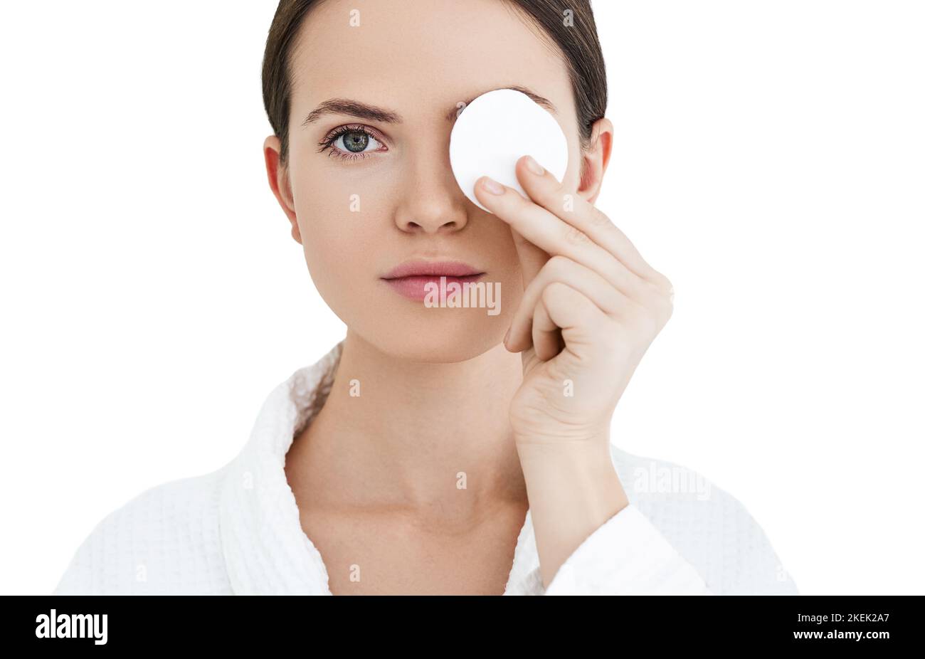 Attraktive Frau kümmert sich um die Haut mit kosmetischen Baumwoll-Pad in der Nähe ihres Gesichts Stockfoto