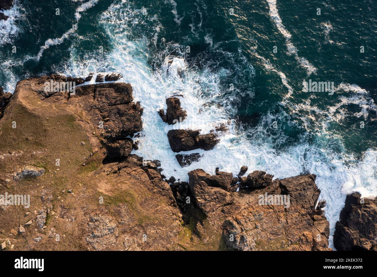 Wunderschöne Luftdrohnen-Landschaftsaufnahme aus der Vogelperspektive von Wellen, die über Felsen an der Küste krachen Stockfoto