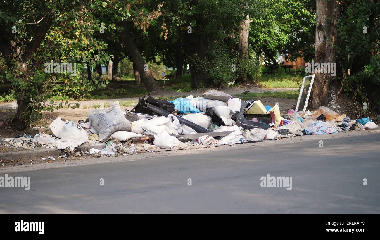 Auf dem Boden, am Straßenrand liegt viel Müll. Verstreuter Müll, Müll, alte Sachen, Autoreifen, kaputtes Glas, Plastik. Müllhalde. Ökologie, Umweltverschmutzung. Hochwertige Fotos Stockfoto