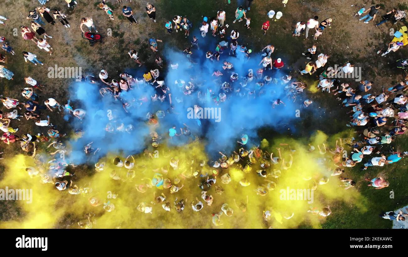 TSCHERKASY, UKRAINE - 24. AUGUST 2018 : Luftvideo mit Drohne, Feier des Unabhängigkeitstages, Fest der Farben, Menschen werfen gelbe und blaue Farben in den Himmel, Nationalflagge. Hochwertige Fotos Stockfoto