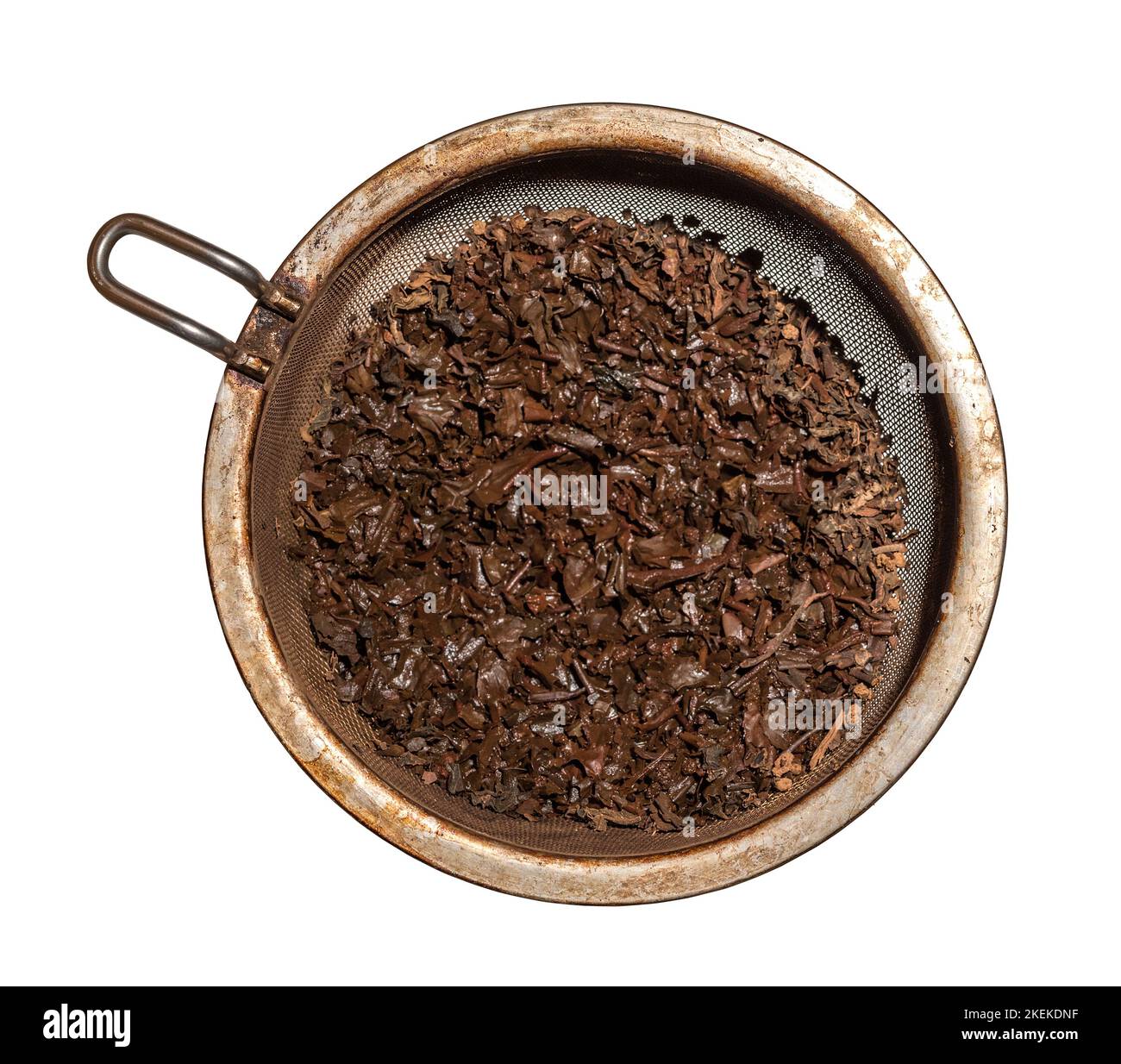 Gebraute, nasse Teeblätter in einem Metallsieb, isoliert vor weißem Hintergrund Stockfoto
