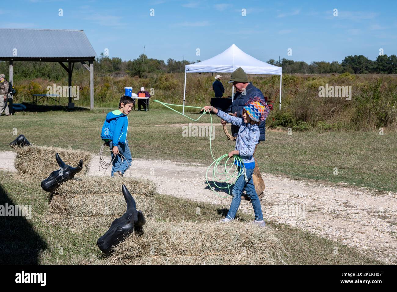 Ein Mann, der Kindern beibringt, wie man in einem Park ein Seil wirft. Houston, Texas, USA. Stockfoto