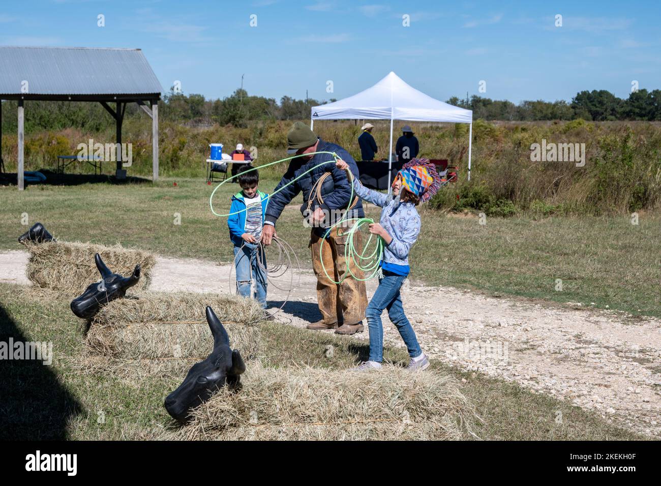Ein Mann, der Kindern beibringt, wie man in einem Park ein Seil wirft. Houston, Texas, USA. Stockfoto