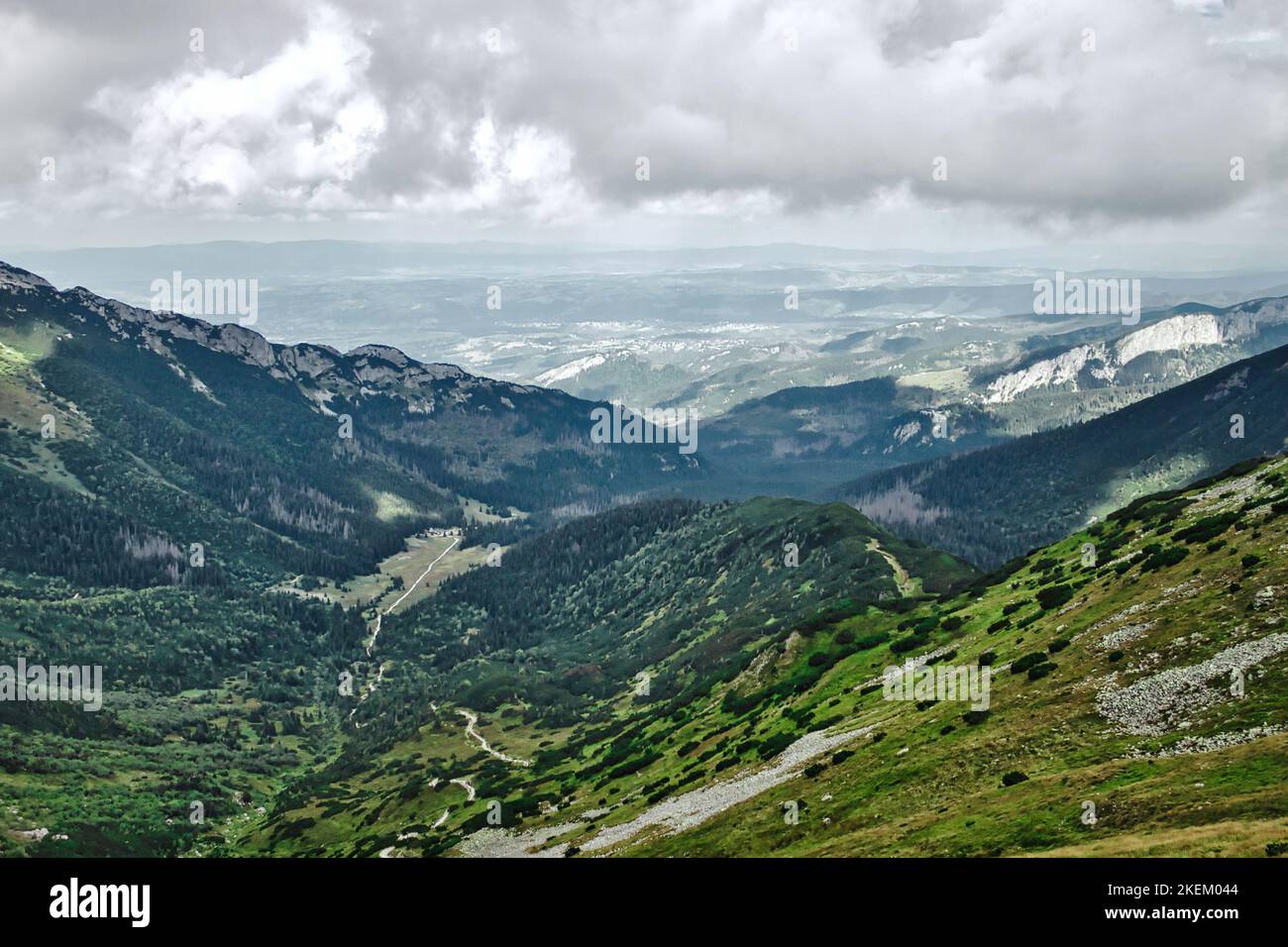 Landschaftlich schöner Blick über das Tal mit immergrünen Wäldern, felsigen Klippen, Wanderwegen und Zakopane Stadt in der Ferne in Polen vom Tatra Nationalpark Stockfoto