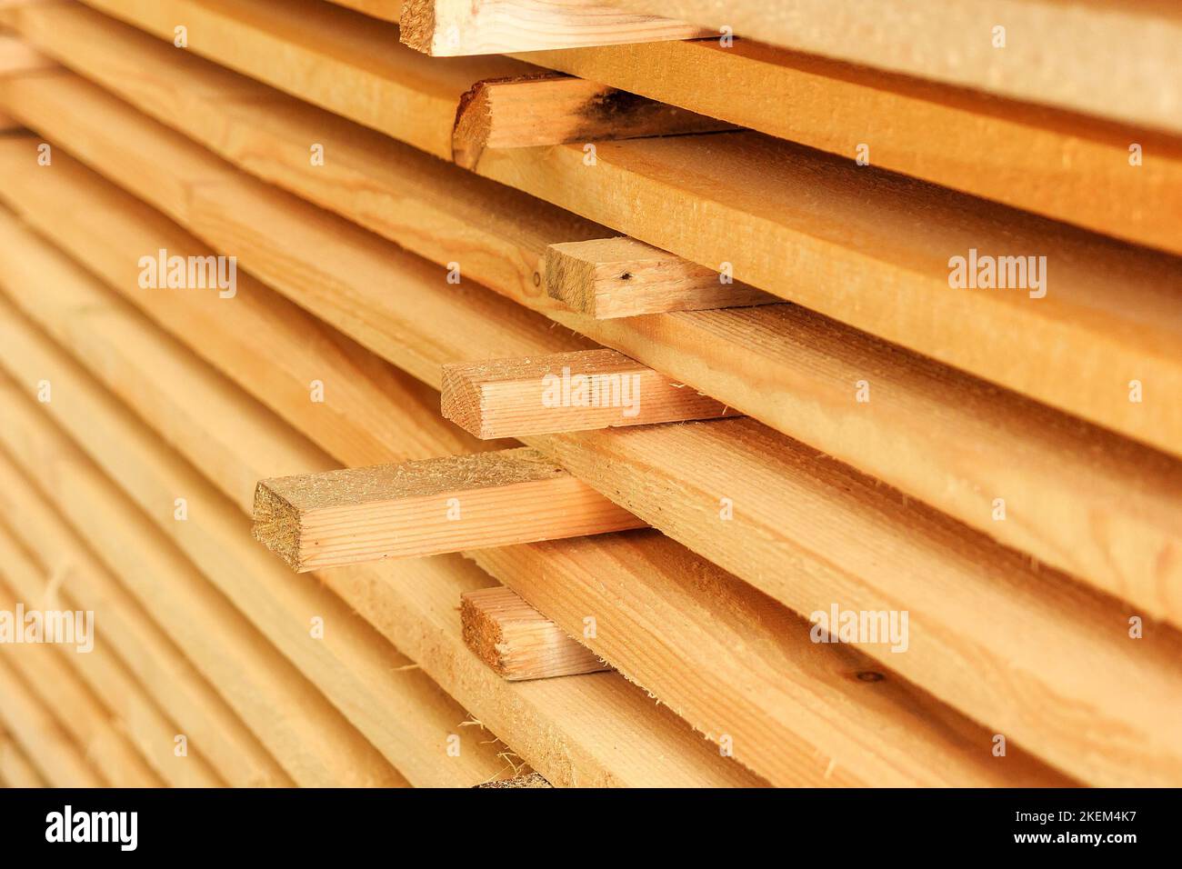 Holzbretter werden in einem Sägewerk oder einer Schreinerei gestapelt. Sägen Trocknen und Vermarktung von Holz. Industrieller Hintergrund. Stockfoto