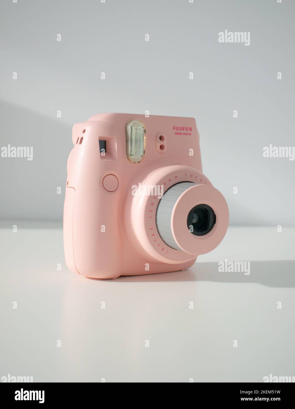 Eine vertikale Aufnahme einer pinken Fujifilm Polaroid Instax mini8 auf weißem Hintergrund Stockfoto