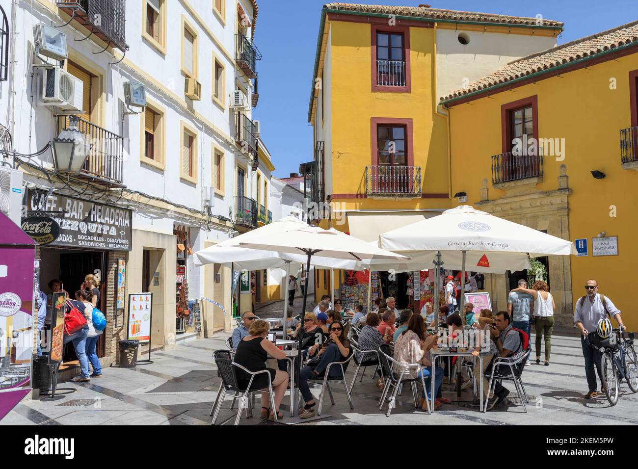 Gäste genießen Getränke und Snacks an Tischen auf einem verkehrsfreien Platz vor dem Café. Cordoba, Provinz Cordoba, Andalusien, Südspanien. Das Histo Stockfoto