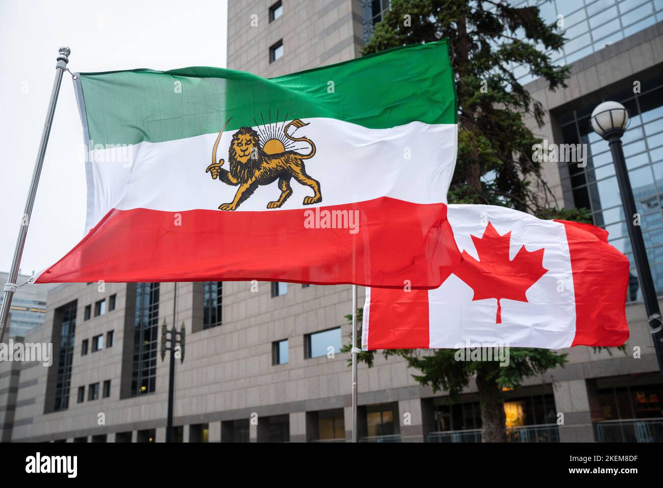 Kanadische und iranische shir-o-khorshid-Flaggen fliegen bei einem Ereignis in Toronto Seite an Seite, um sich mit iranischen Demonstranten solidarisch zu zeigen, die für ein Ende des Regimes kämpfen. Stockfoto