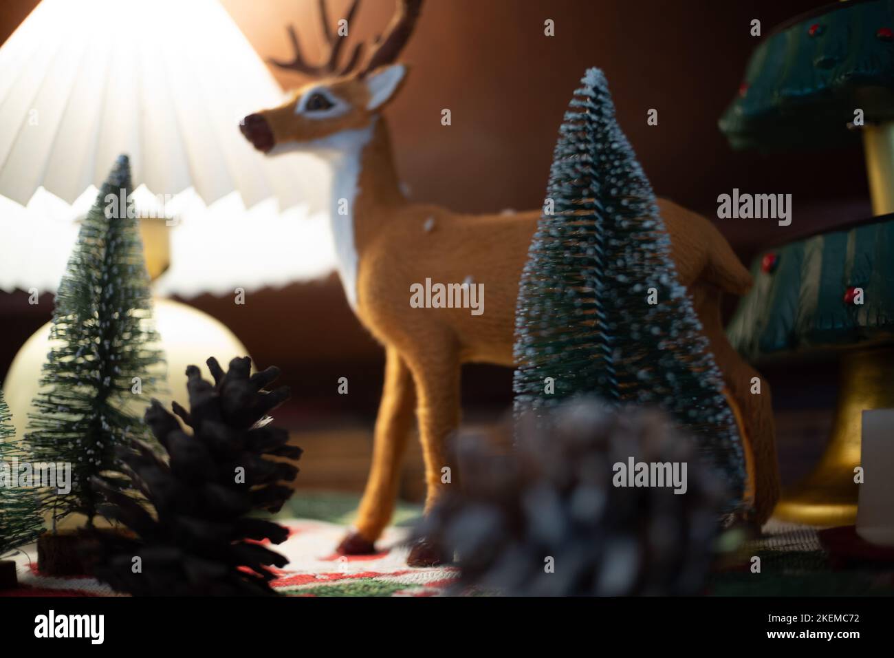 Nahaufnahme Weihnachtsdekoration von Weihnachtsbaum und Rentiertür und helle Lampe auf dem Tischhintergrund. Stockfoto