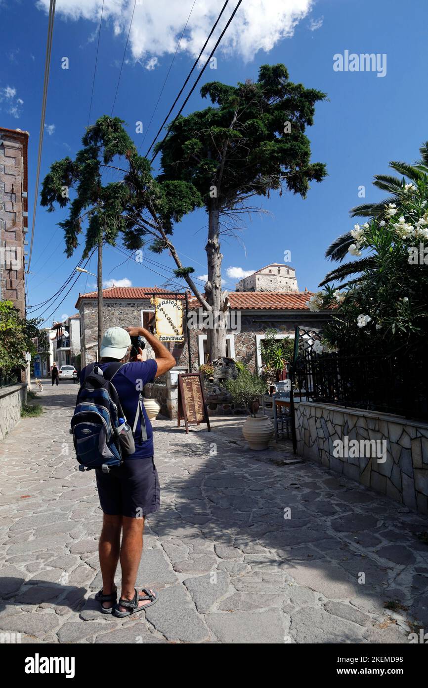 Fotograf, der die Straßenszene und die Kirche „Our Lady of the Sweet Kiss“ macht. Petra, Lesbos. Oktober Stockfoto