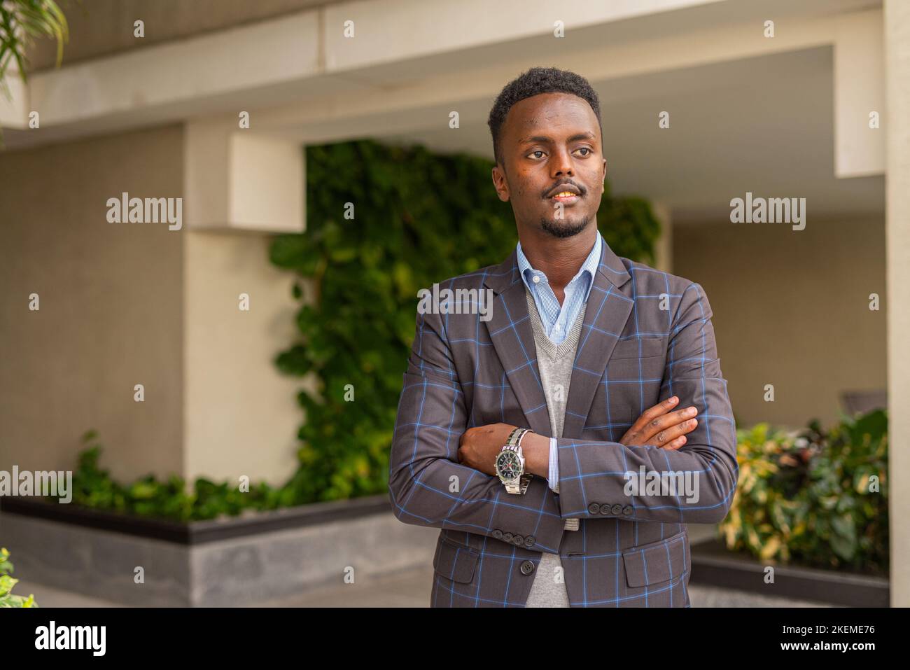 Porträt eines hübschen schwarzen afrikanischen Geschäftsmannes, der Anzug trägt, während er im Freien denkt Stockfoto