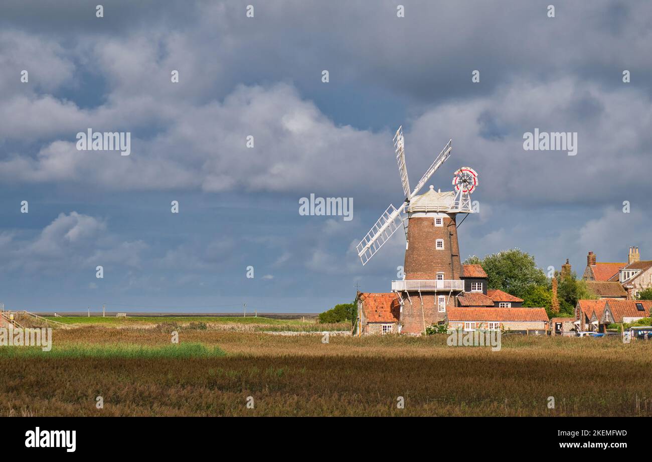 Vom North Norfolk Coast Path aus bietet sich ein Blick über die Feuchtgebiete der Küste und die denkmalgeschützte Turmmühle Cley in der Nähe des Meeres mit 2 Grad. Stockfoto