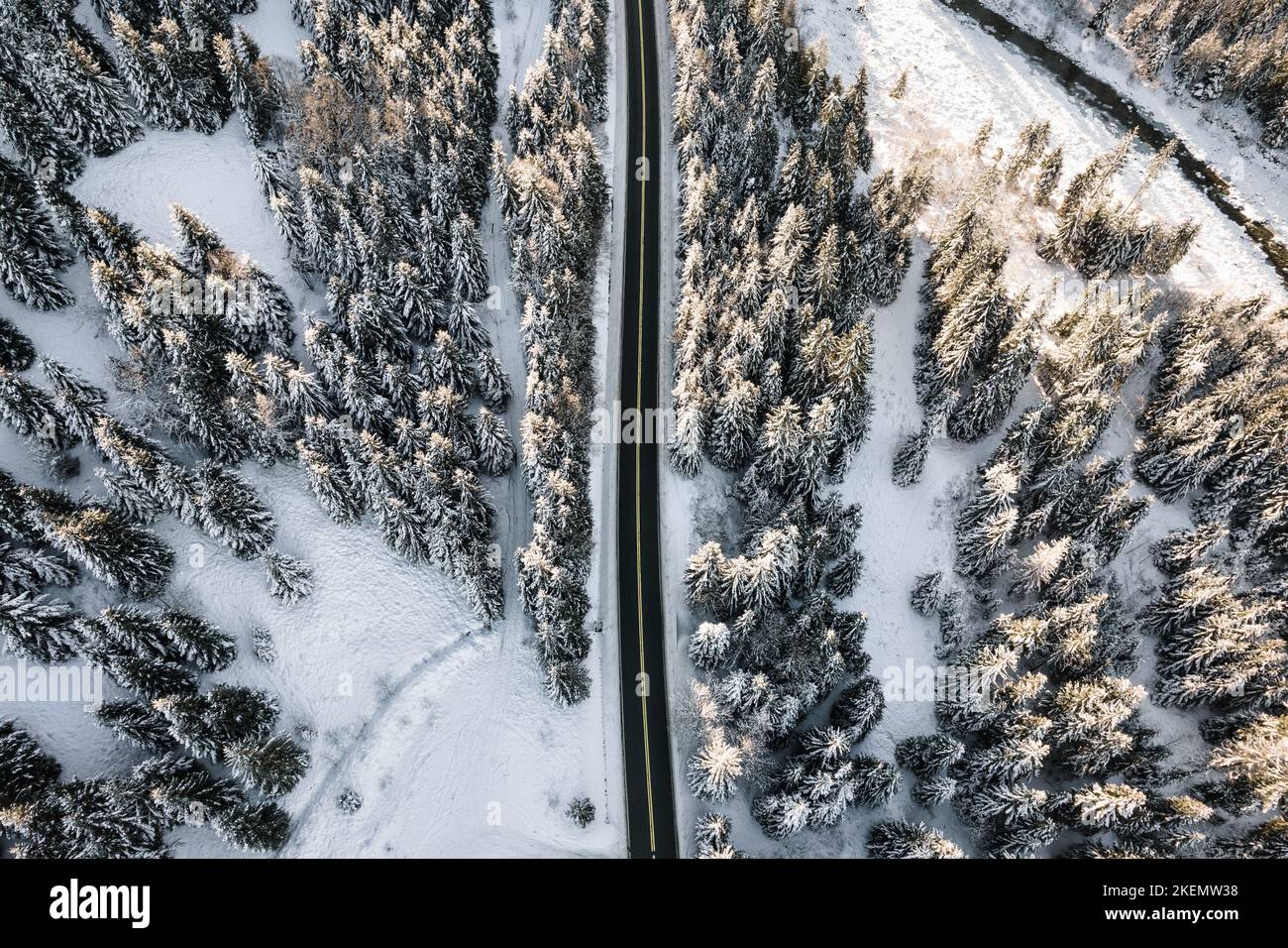 Luftaufnahme der Bergstraße im Winter. Epischer, schneeweißer Winter in den Bergen. Schneebedeckte Fichten, gefrorener Wald. Stockfoto