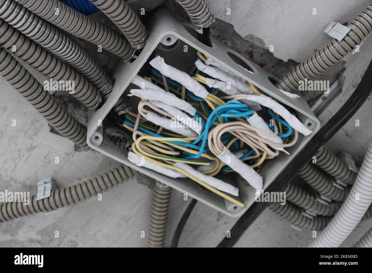 Verdrehen der elektrischen Leitungen im Anschlusskasten während der Installation der elektrischen Leitungen im Raum Stockfoto