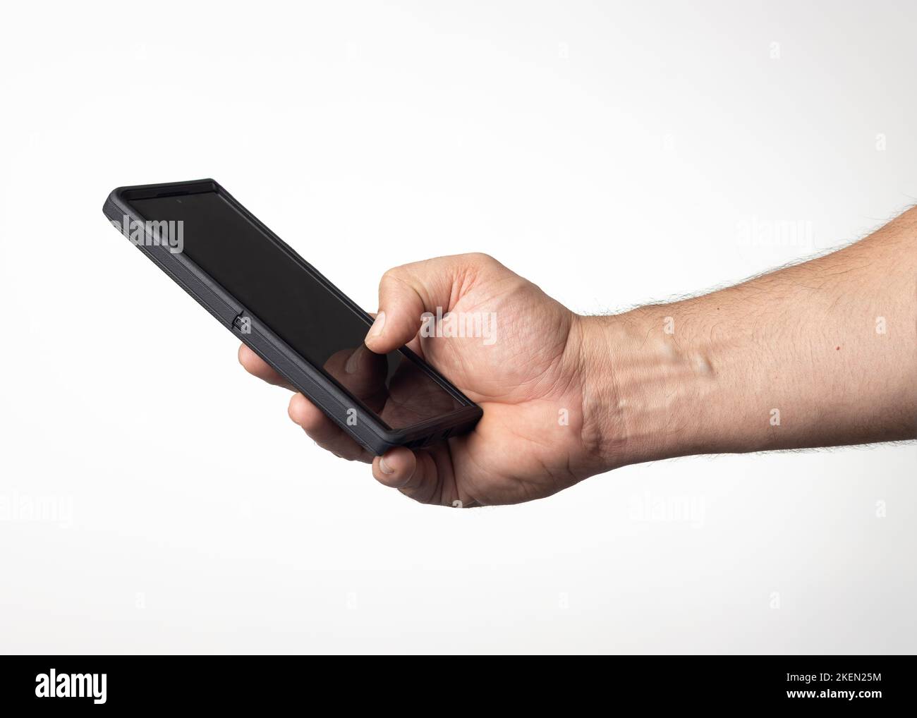 Hand und Arm eines Mannes, der ein Mobiltelefon mit einem schwarzen Bildschirm auf einem kernweißen Hintergrund hält. Stockfoto