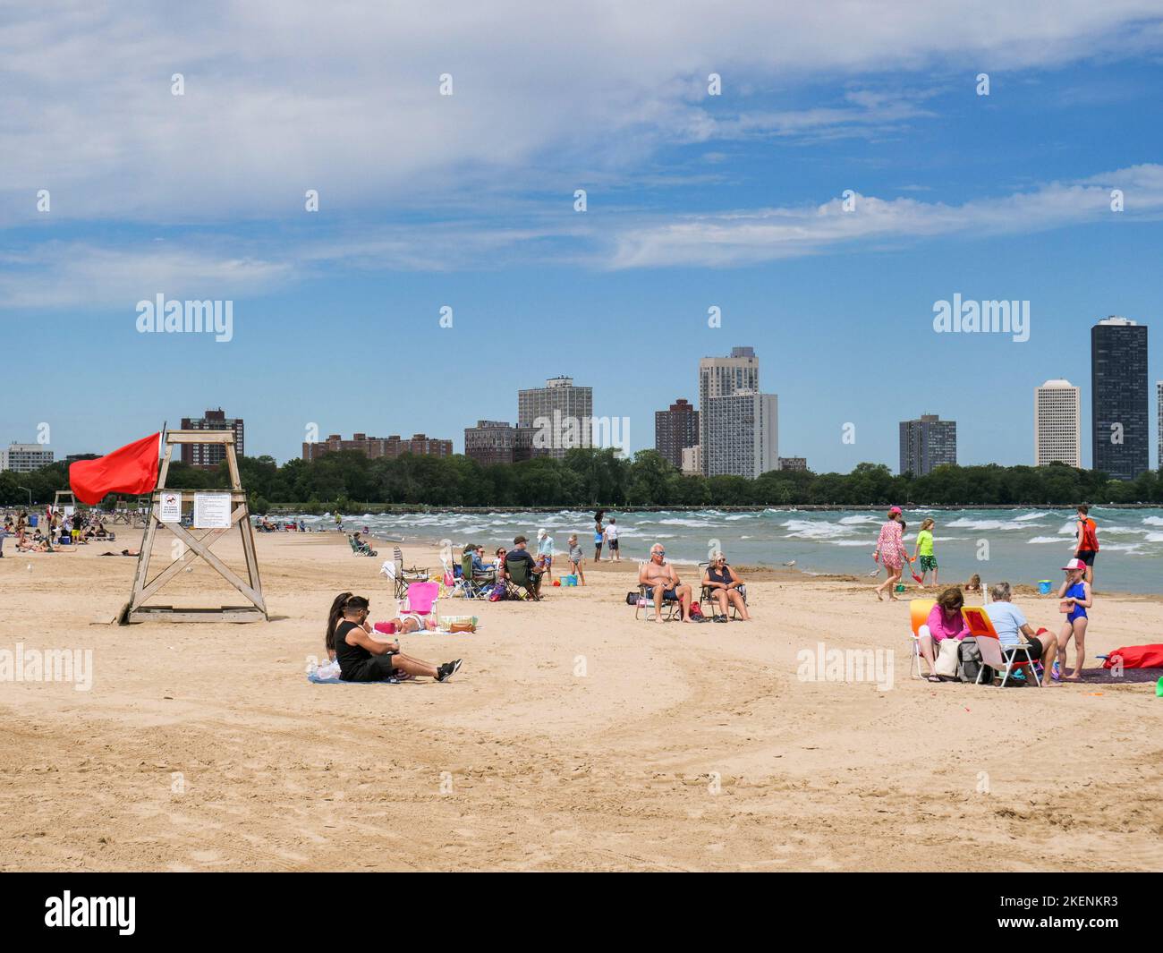 Strandgänger am Montrose Beach, Chicago, Illinois. Die rote Flagge weist darauf hin, dass aufgrund der rauhen Brandung kein Schwimmen erlaubt ist. Stockfoto
