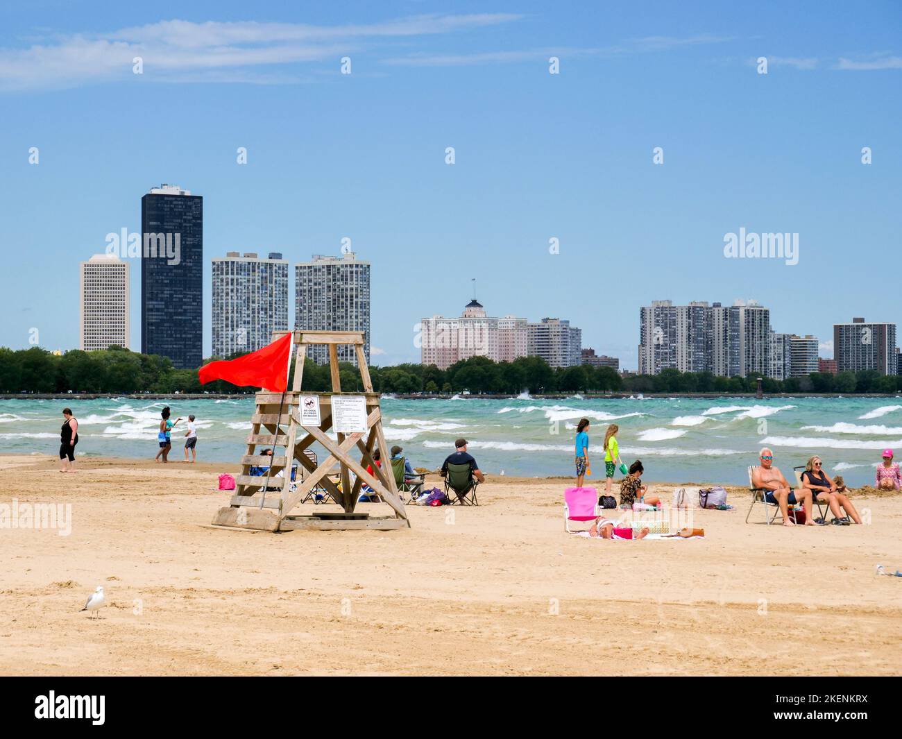 Strandgänger am Montrose Beach, Chicago, Illinois. Die rote Flagge weist darauf hin, dass aufgrund der rauhen Brandung kein Schwimmen erlaubt ist. Stockfoto