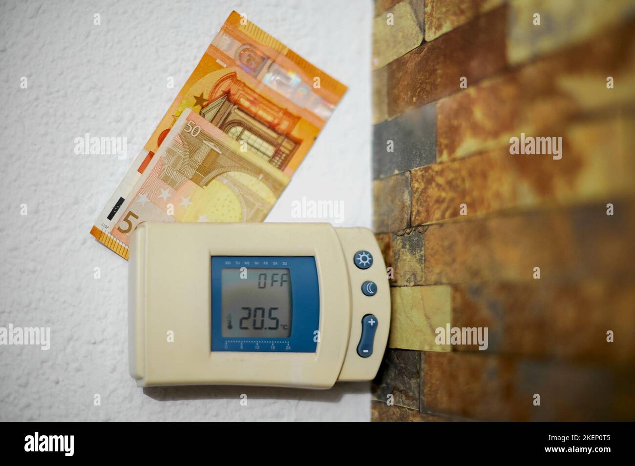 Heizthermostat-Controller mit Euro-Bargeld auf der Oberseite an einer Wand eines Hauses. Stockfoto