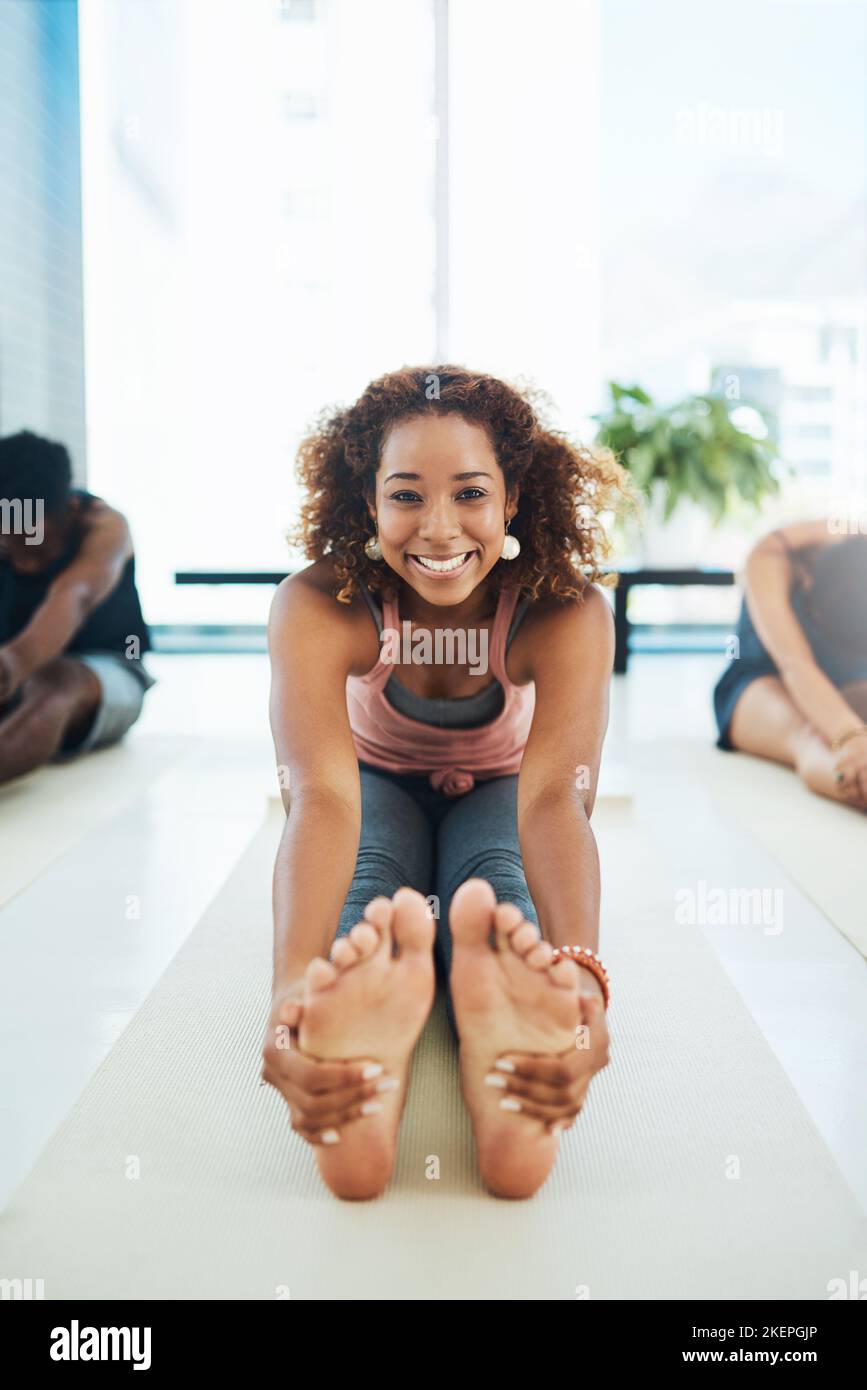 Dehnung ist sehr wichtig. Portraitaufnahme einer jungen, fit getrampten Gruppe von Menschen, die eine Yoga-Pose auf dem Boden in einem Studio machen. Stockfoto