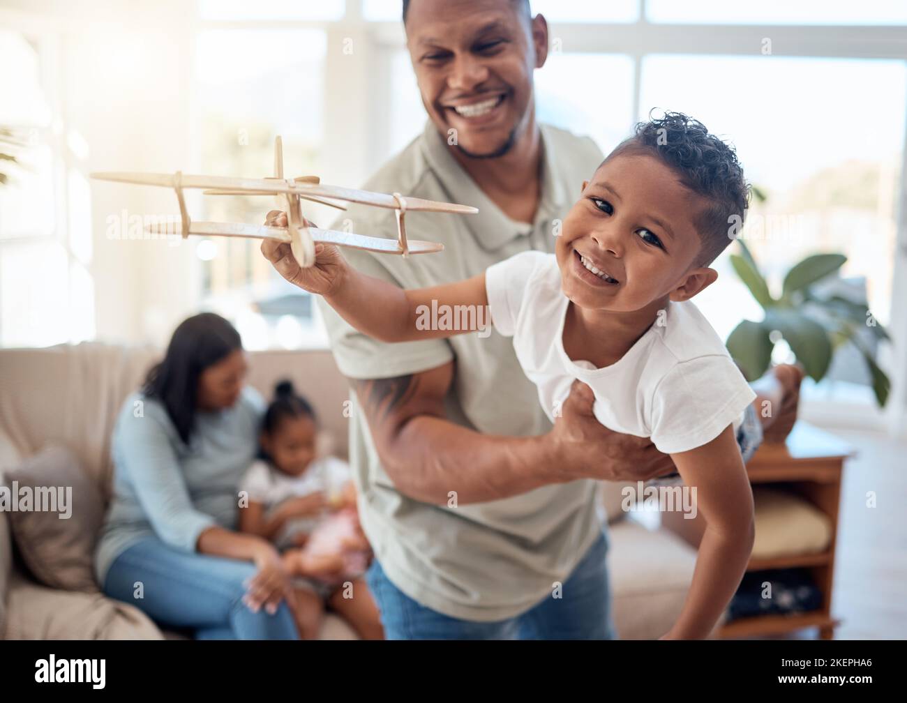 Papa, Junge und Spielzeug Flugzeug im Wohnzimmer für Spiel, Spaß oder Bindung, während glücklich zusammen. Vater, Sohn und spielen Flugzeugspielzeug mit Lächeln im Haus mit Liebe Stockfoto