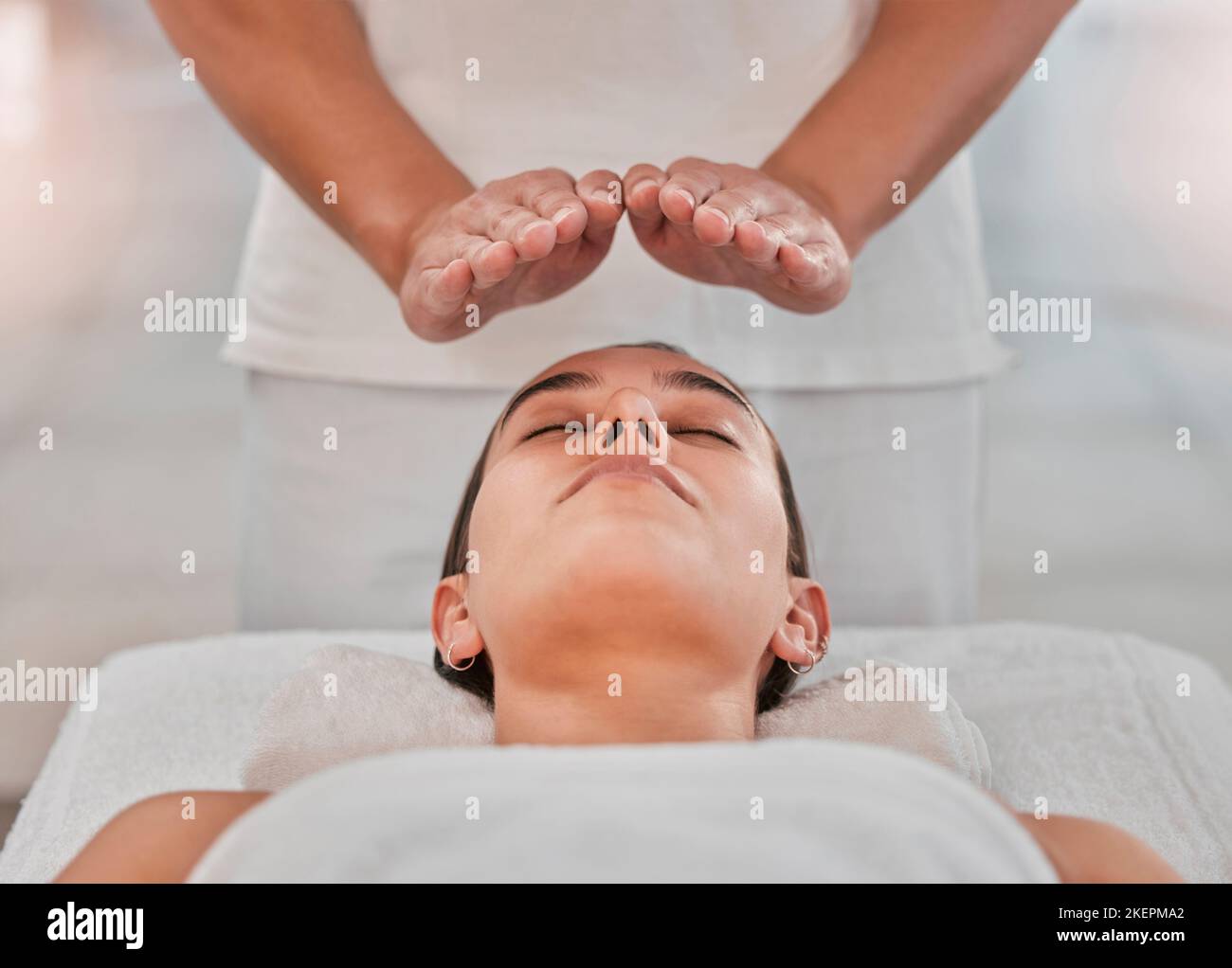 Entspannen, Gesundheit und reiki mit Frau auf Spa-Tisch für heilende Energie, Zen und alternative Medizin. Ruhe, Wellness und Luxus mit Massagehands Stockfoto