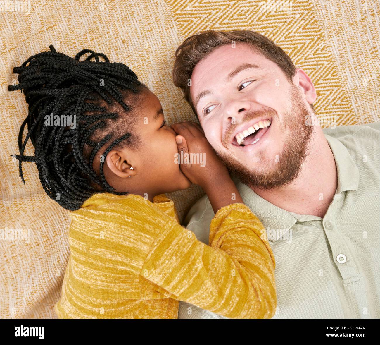 Glücklich, flüstern Geheimnis und Kind in einer interracial Familie mit Vater mit einem Lächeln über Adoption oben. Vater, Mädchen und Kind kümmern sich um einen Mann mit Glück Stockfoto
